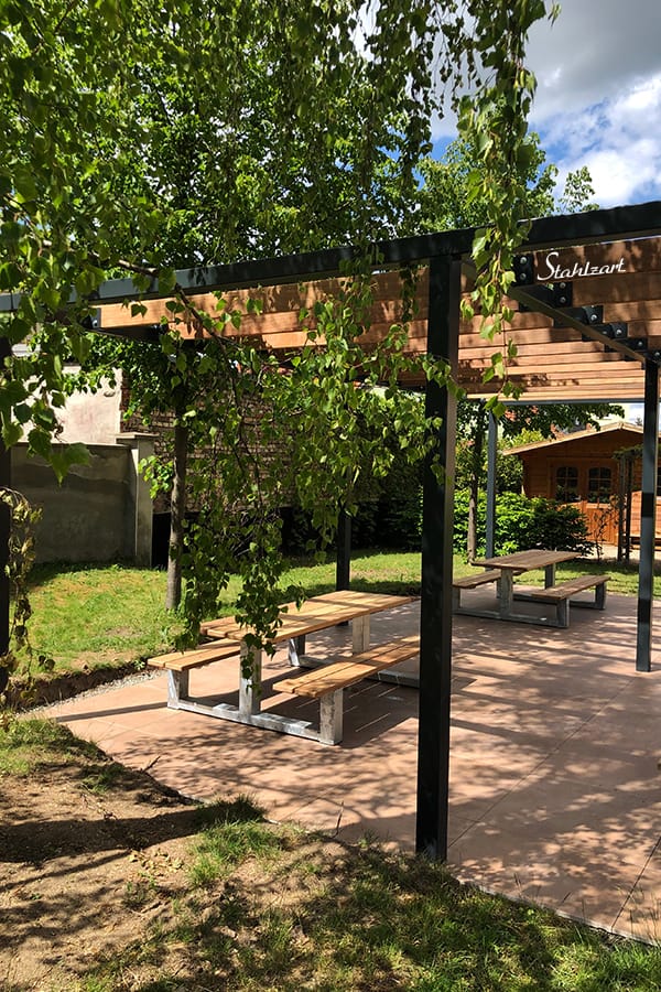 pergola-pavillon-gruenes-klassenzimmer-garten-mit-moebel-bank-lamellendach-ueberdachung-stahl-material-holz-modern-design-stahlzart