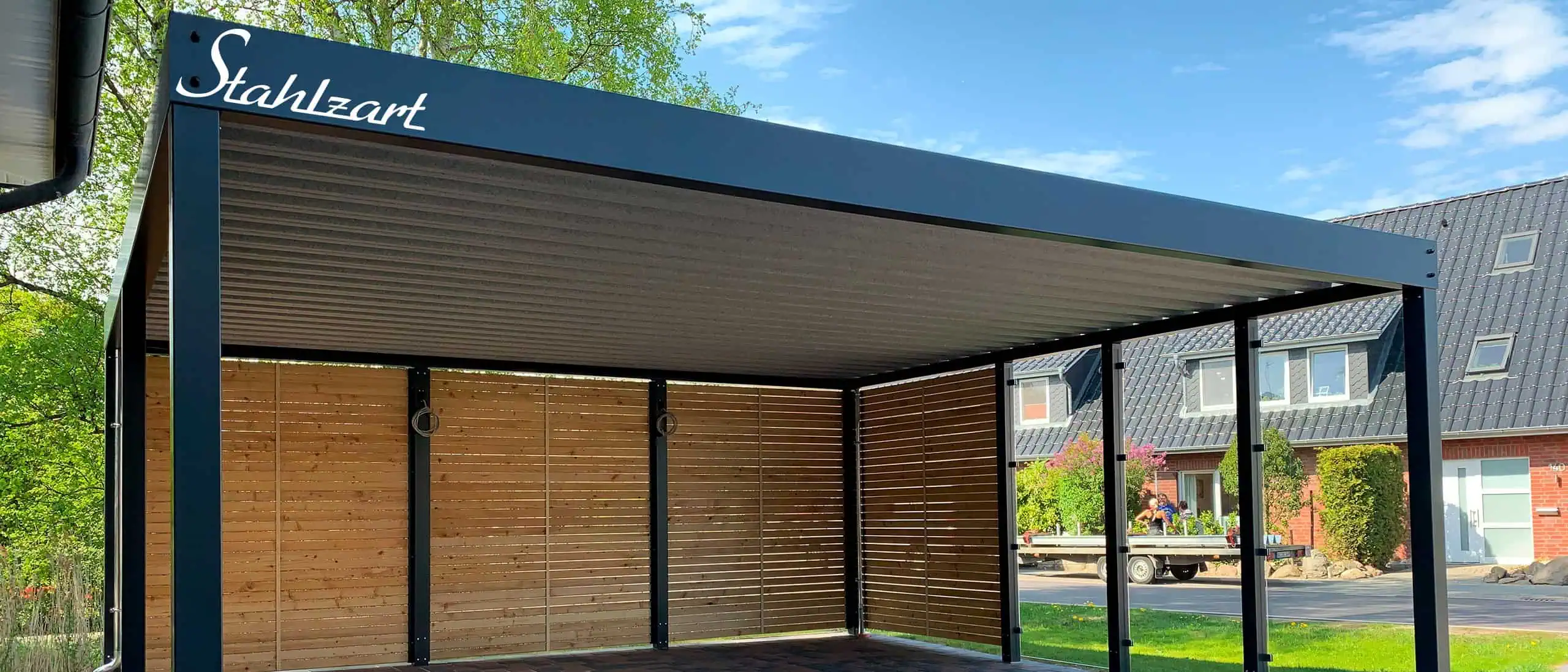 Moderner Doppelcarport aus Stahl mit Glas- und Holzwand und Anthrazit-Flachdach in Teltow