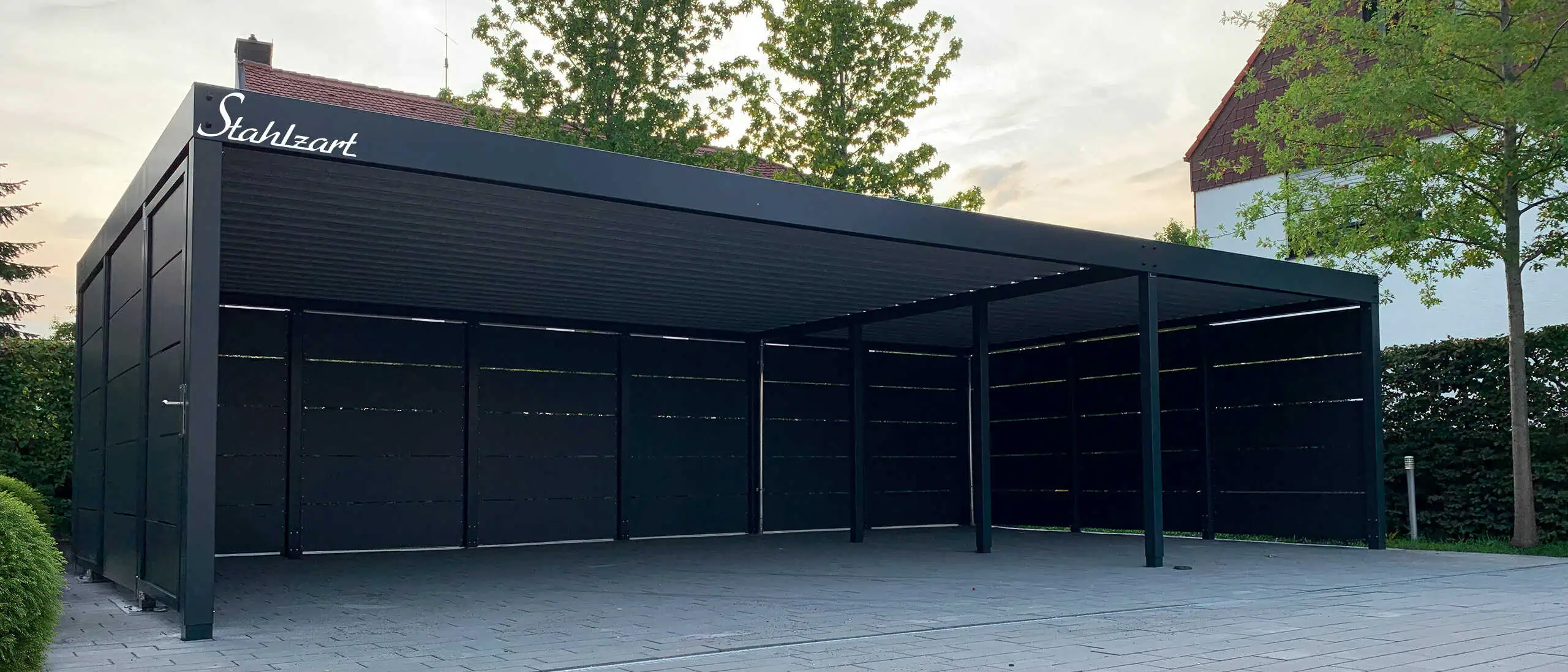 Moderner Reihencarport aus verzinktem Stahl in Steglitz-Zehlendorf mit Seitentür und Flachdach in Anthrazit