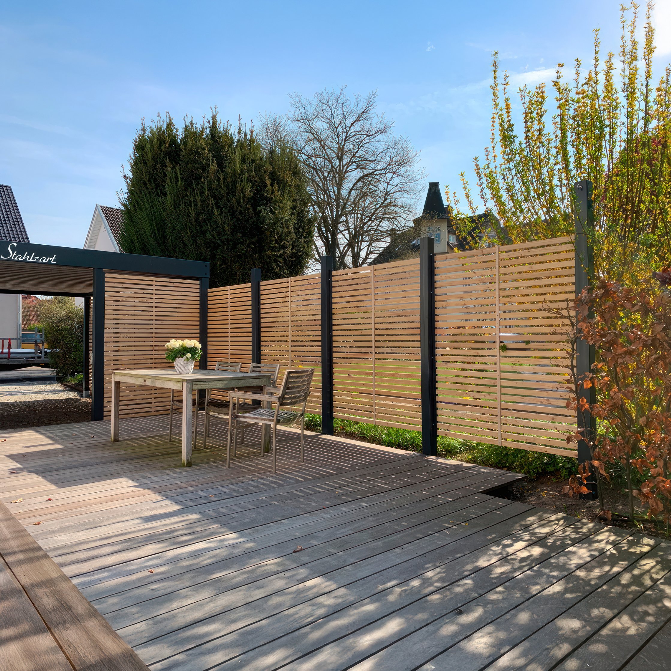 Stahlzart Carport nach Maß mit individuellem Anbau Individueller Carport nach Maß von Stahlzart als Beispiel einer Sonderlösung mit angebautem Sichtschutzzaun aus Holz und Zugang zur Terrasse.